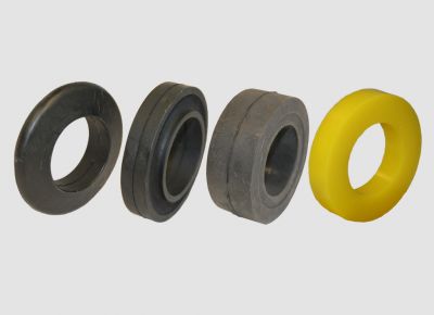 Verschiedene Ringe für Tragrollen im Vergleich: Stützring Form A, Pufferring, Stützring Form B und gelber Polyurethanring nebeneinander aufgereiht